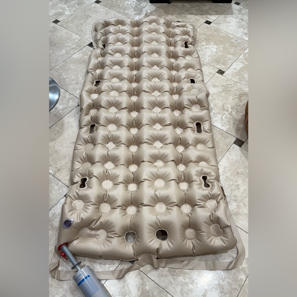 Twin size inflatable mattress with pump for bedridden patients.